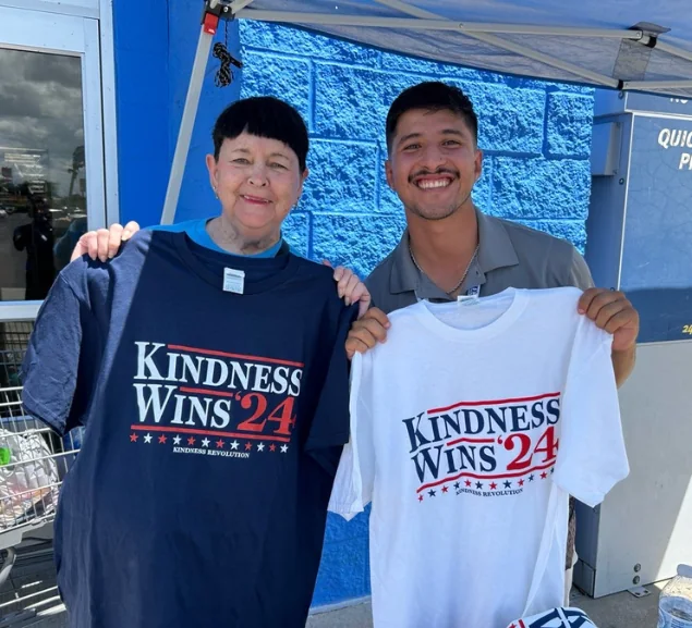 Two GA Jersey Village supporters holding Kindness Wins campaign shirts at a Houston outreach event