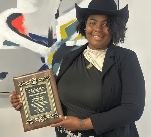 A GA Jersey Village team member holding an award plaque